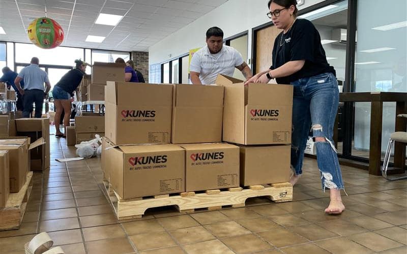 Kunes staff stacking sealed kit boxes onto a pallet
