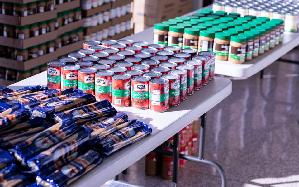 Canned goods and shelf-stable groceries staged for a meal kit build