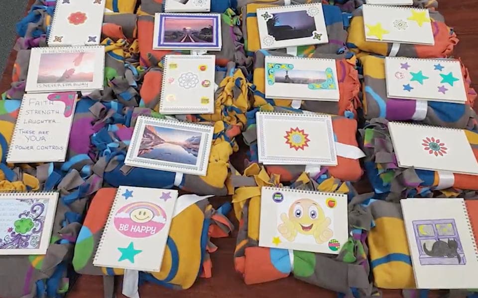 Blankets and hand-written cards packed into cancer care kits