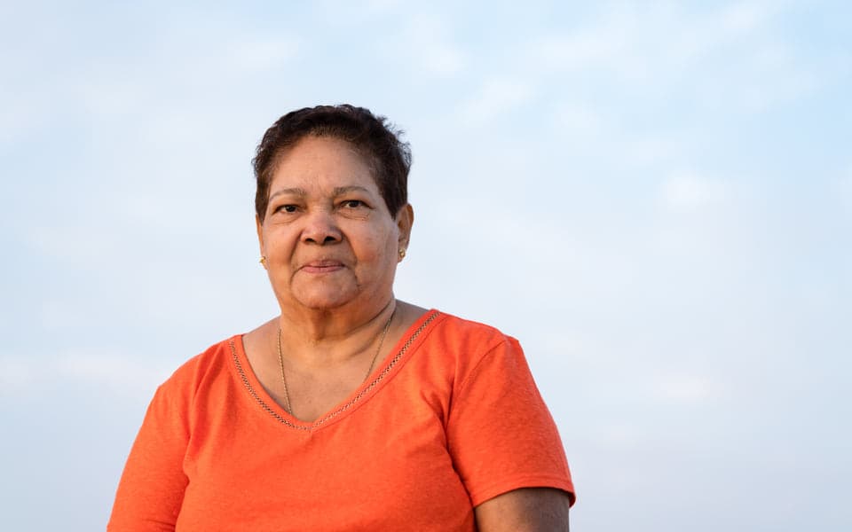 A senior neighbor standing outdoors at dusk